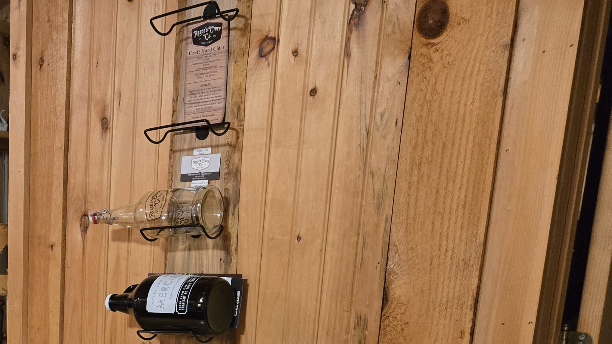 Reece's Cider and Mercier cider bottles on the wall rack at Headwaters cabin in Suches GA