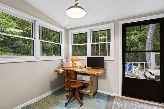 Dedicated workspace with monitor overlooking the deck and trees at Fish Head Lodge in Suches GA